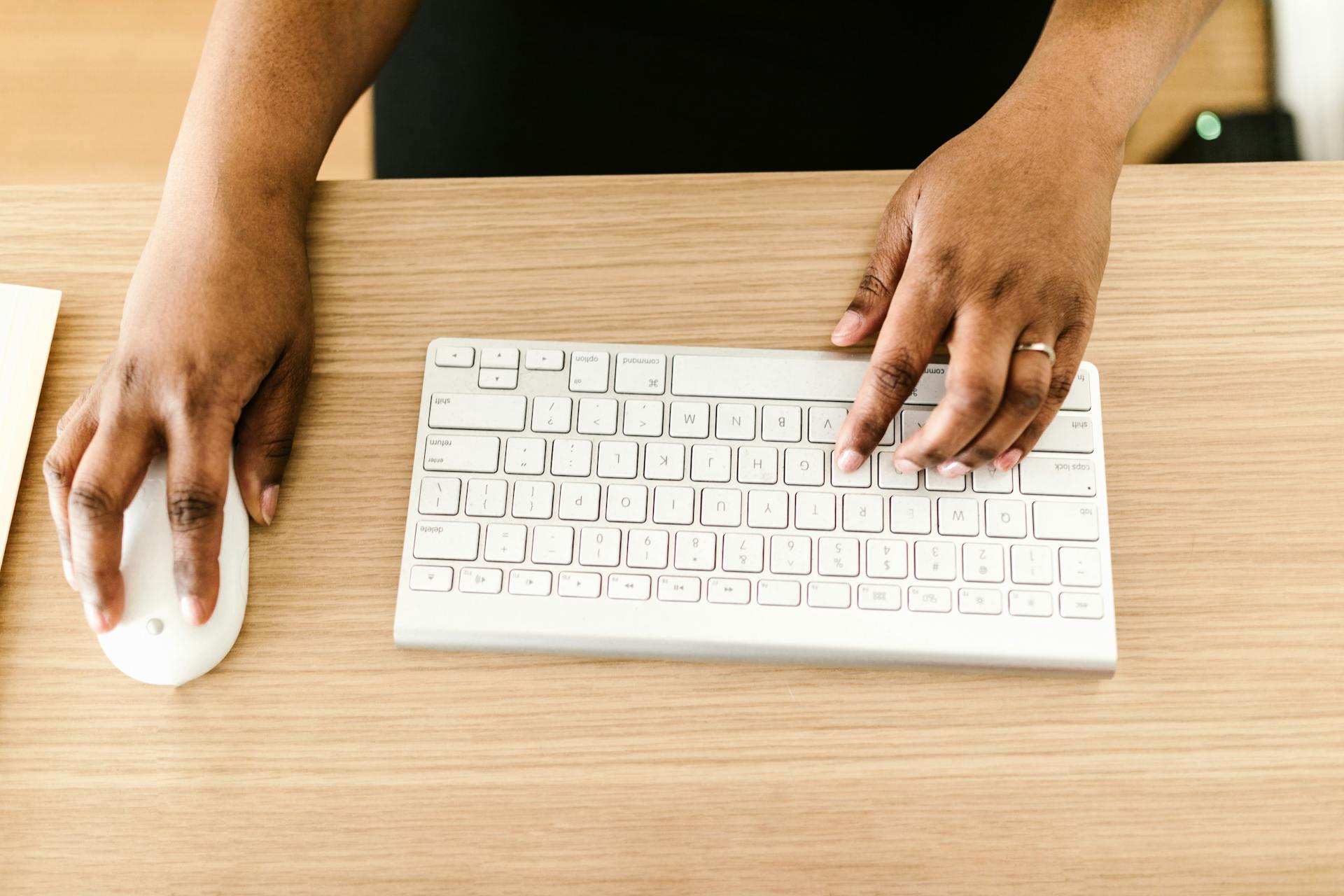 Imagen de unas manos en el teclado y el mouse de un ordenador