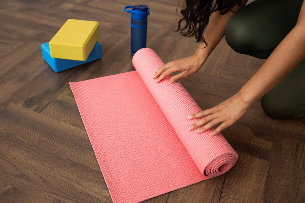 Manos de mujer doblando un Mat de yoga