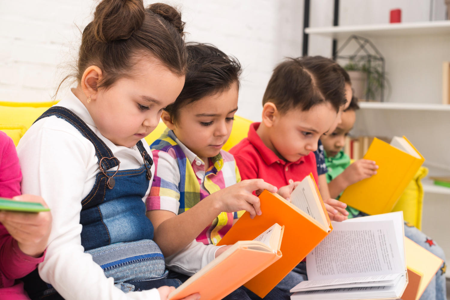 Niños de preescolar leyendo libros