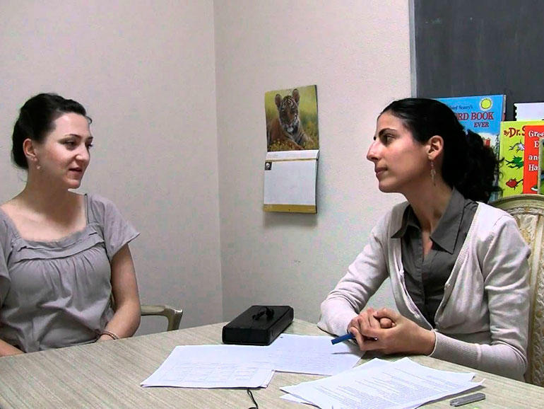 Profesoras sentadas alrededor de una mesa dialogando.