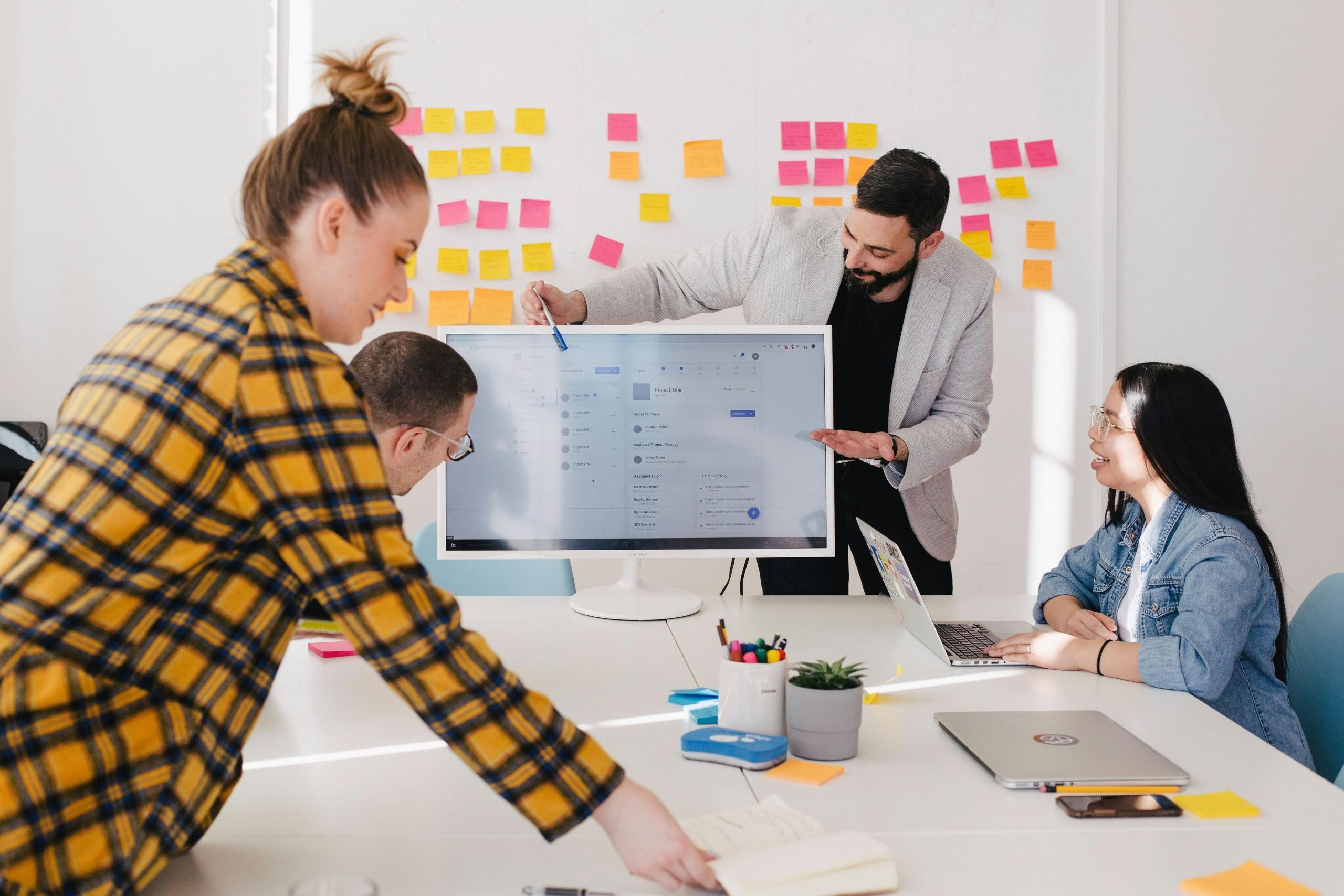 Imagen de 4 personas en una oficina revisando un perfil de Linkedin