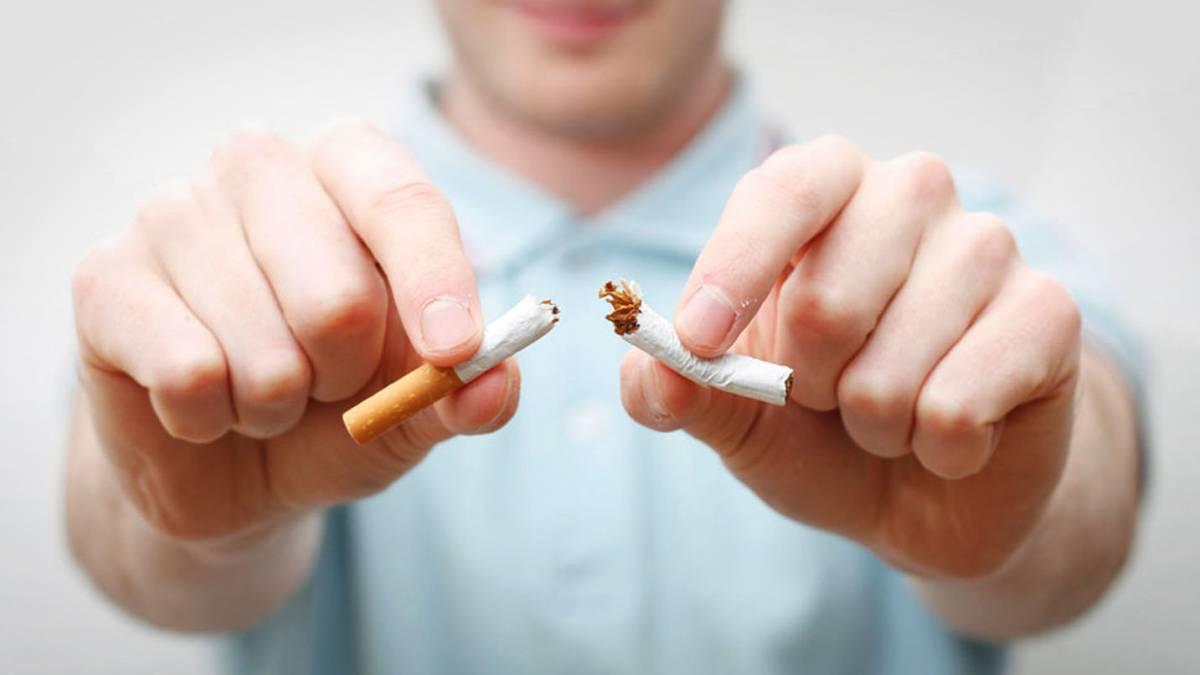 Hombre rompiendo un cigarrillo.