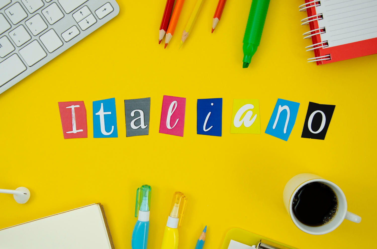Letras de colores con la palabra italiano sobre un escritorio amarillo