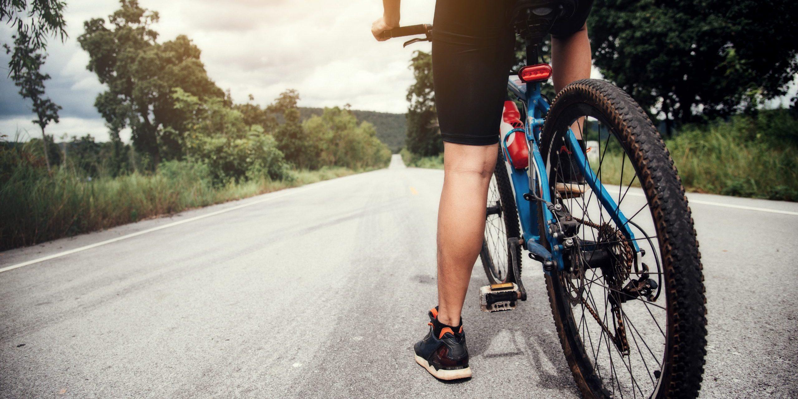 Persona montando Bicicleta por una carretera.