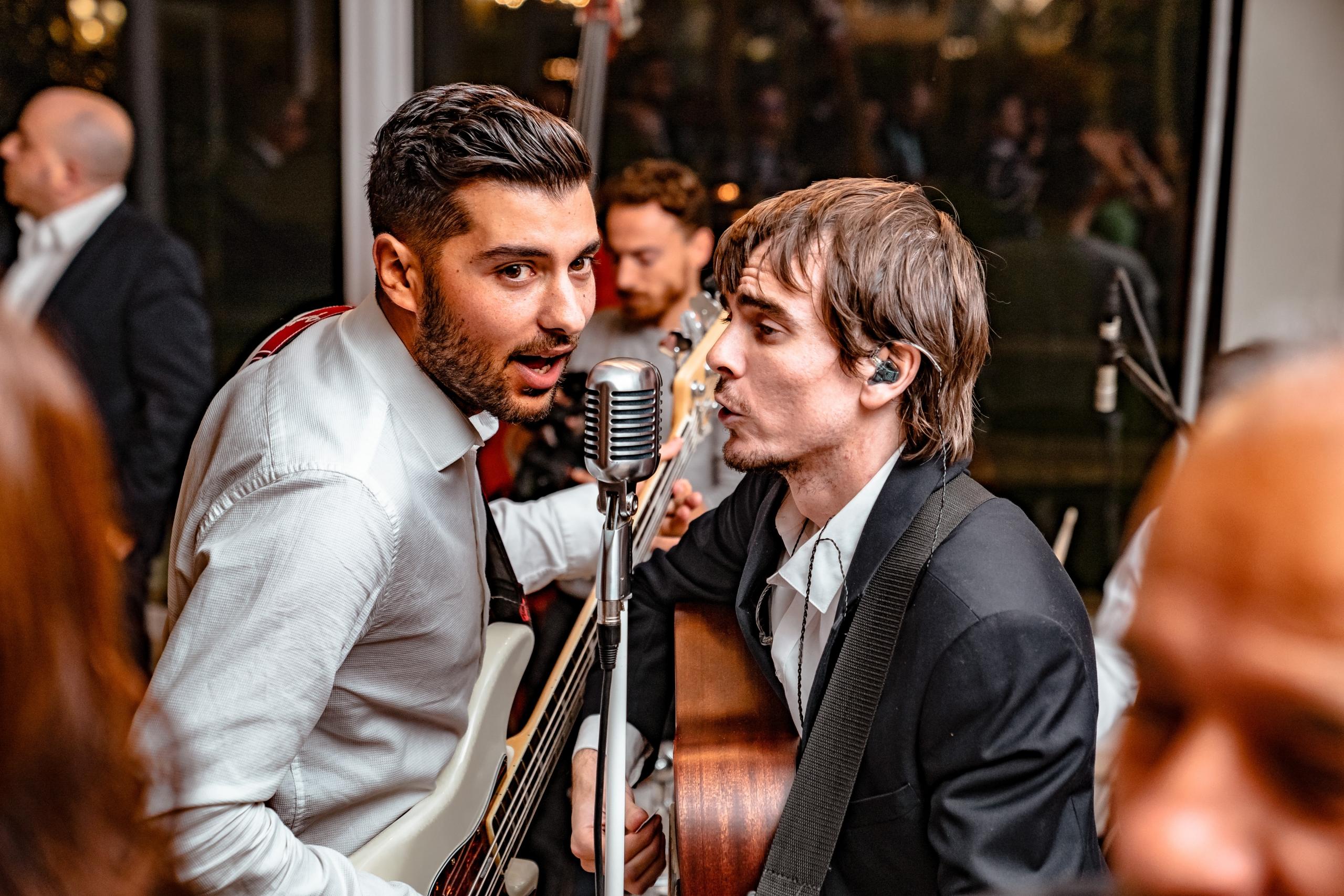 Chicos cantando en un microfono.