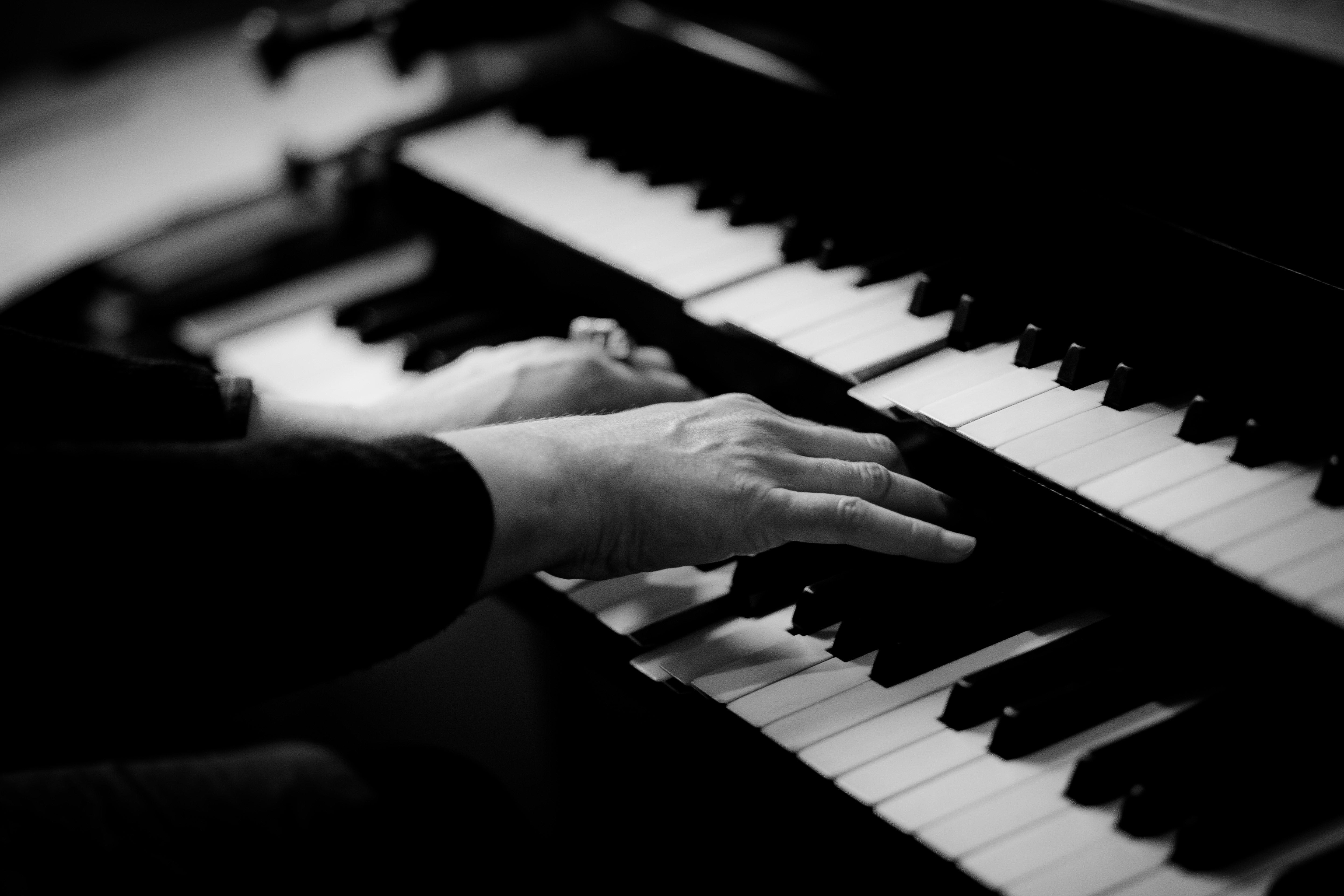Blanco y Negro de unas manos tocando un piano con doble teclado.