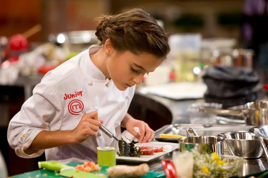 Chica poniendo mucho cuidado a la cantidad de ingredientes que usa para cocinar