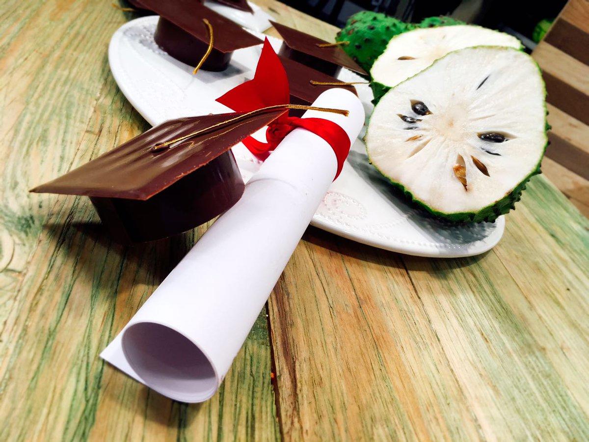 Diploma y algunos Pequeños birretes hechos de chocolate.