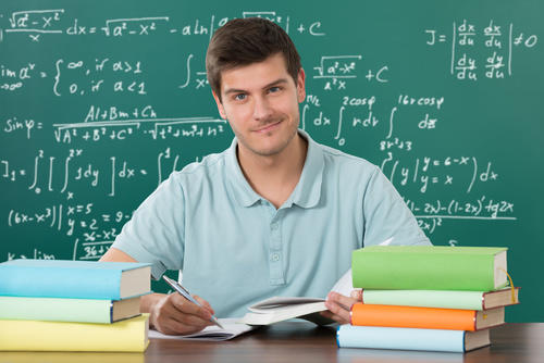Profesor lleno de libros con tablero de fondo y operaciones escritas