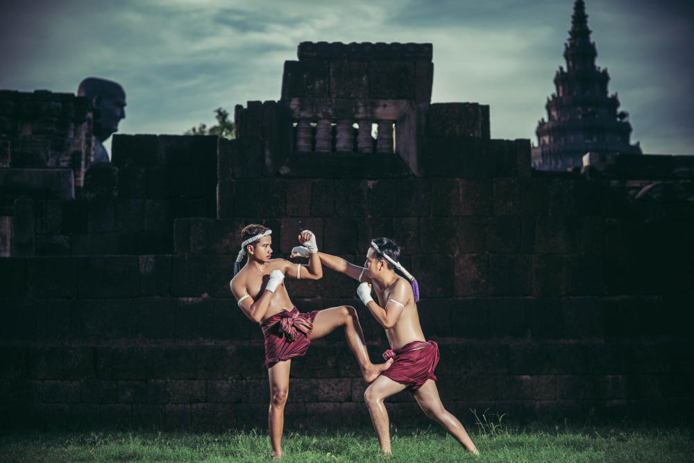 Hombres en combate de Muay Thai al aire libre