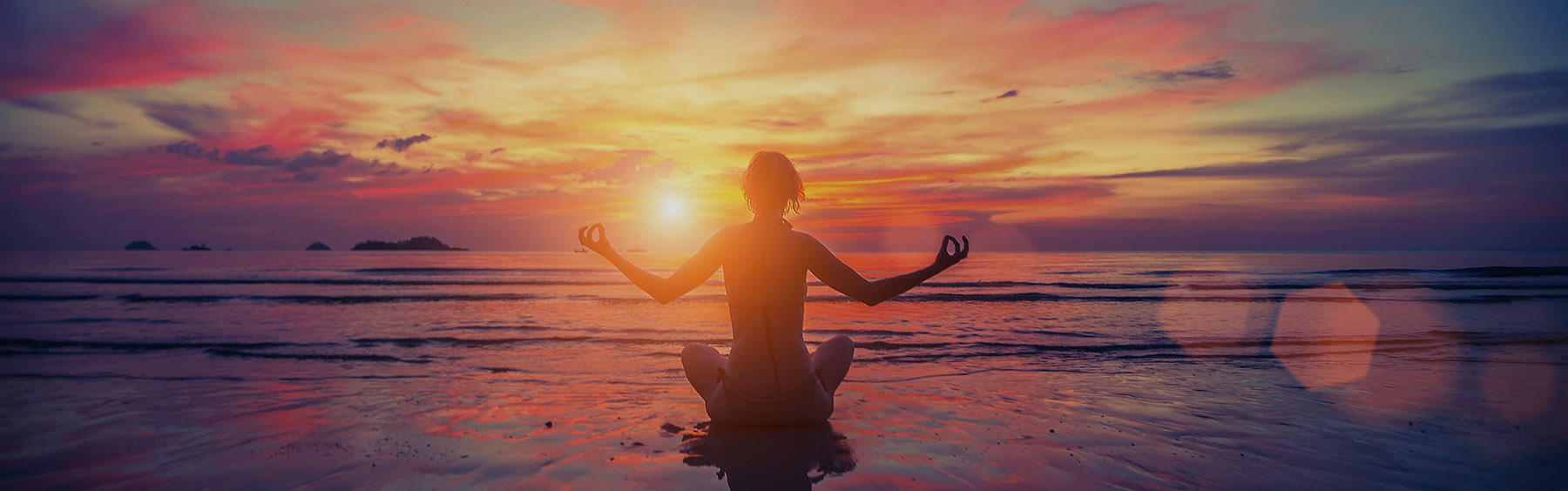 Silueta de una mujer, practicando yoga en la playa.
