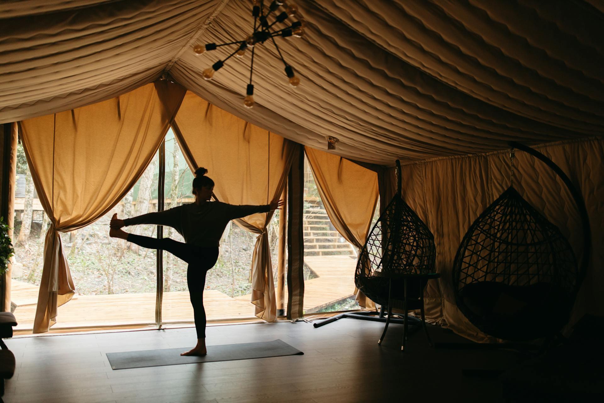 Mujer haciendo posiciones de Vinyasa Yoga en una casa en la playa