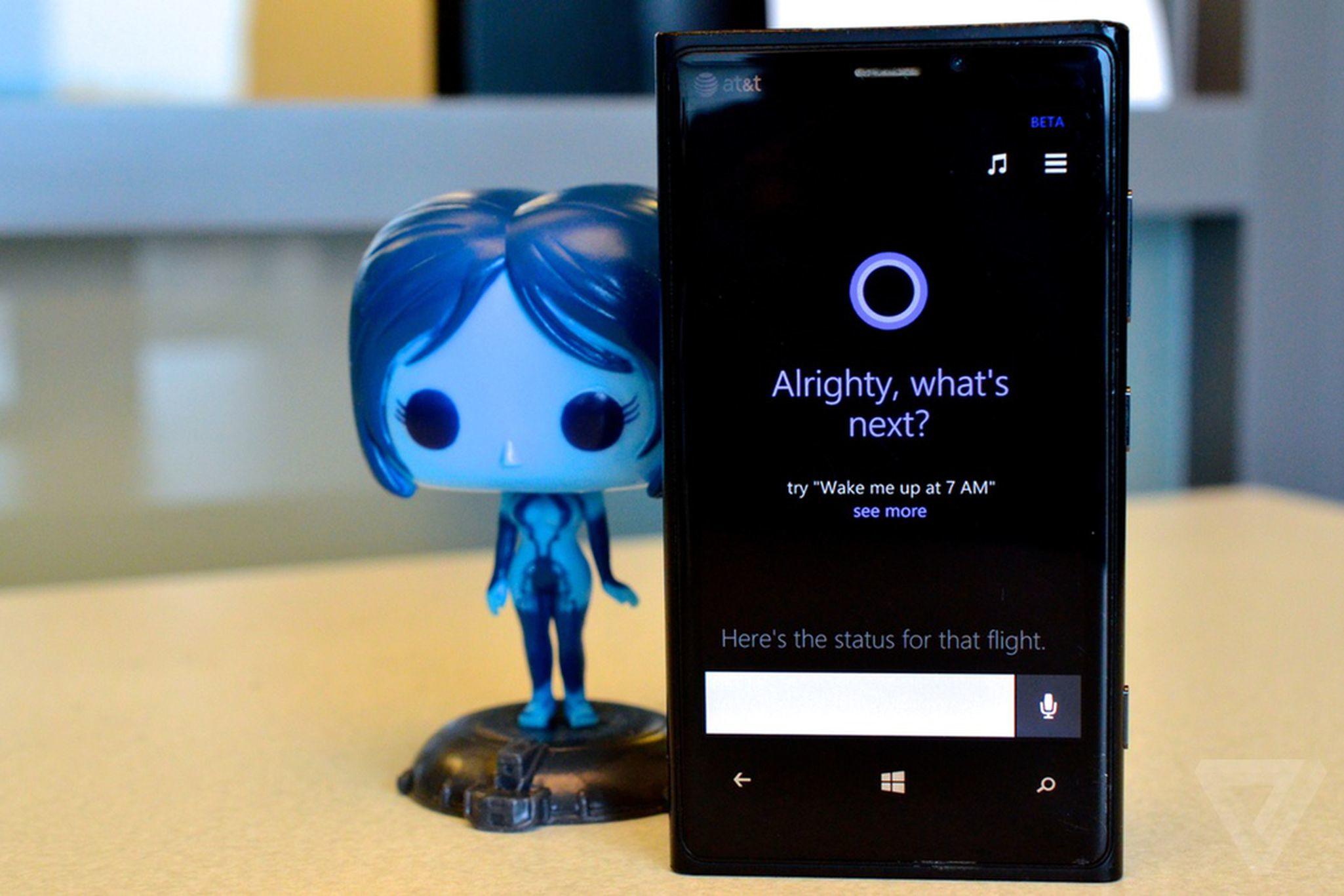 Cortana de pie junto a un teléfono móvil