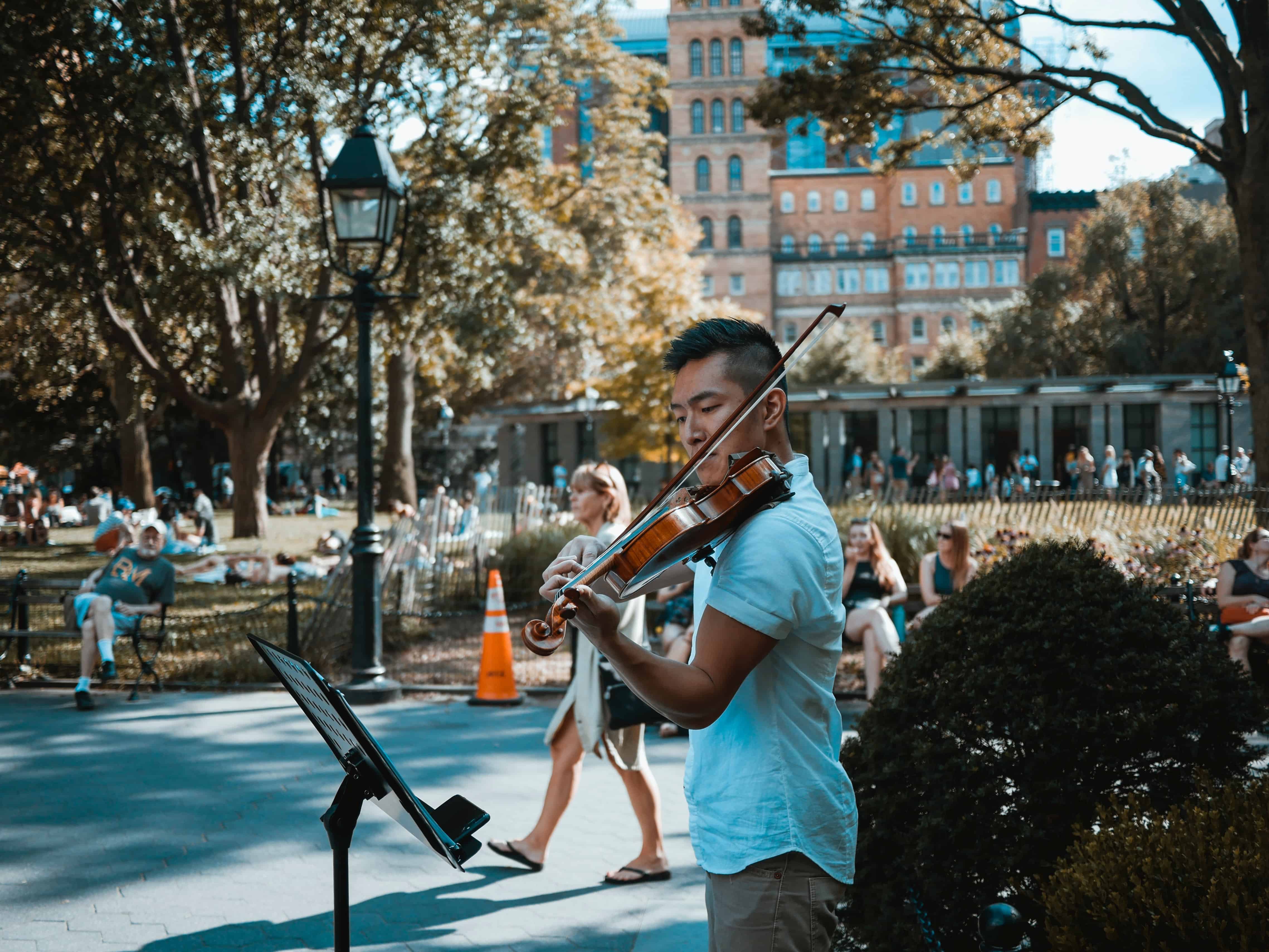 Hombre tocando violín en plaza pública