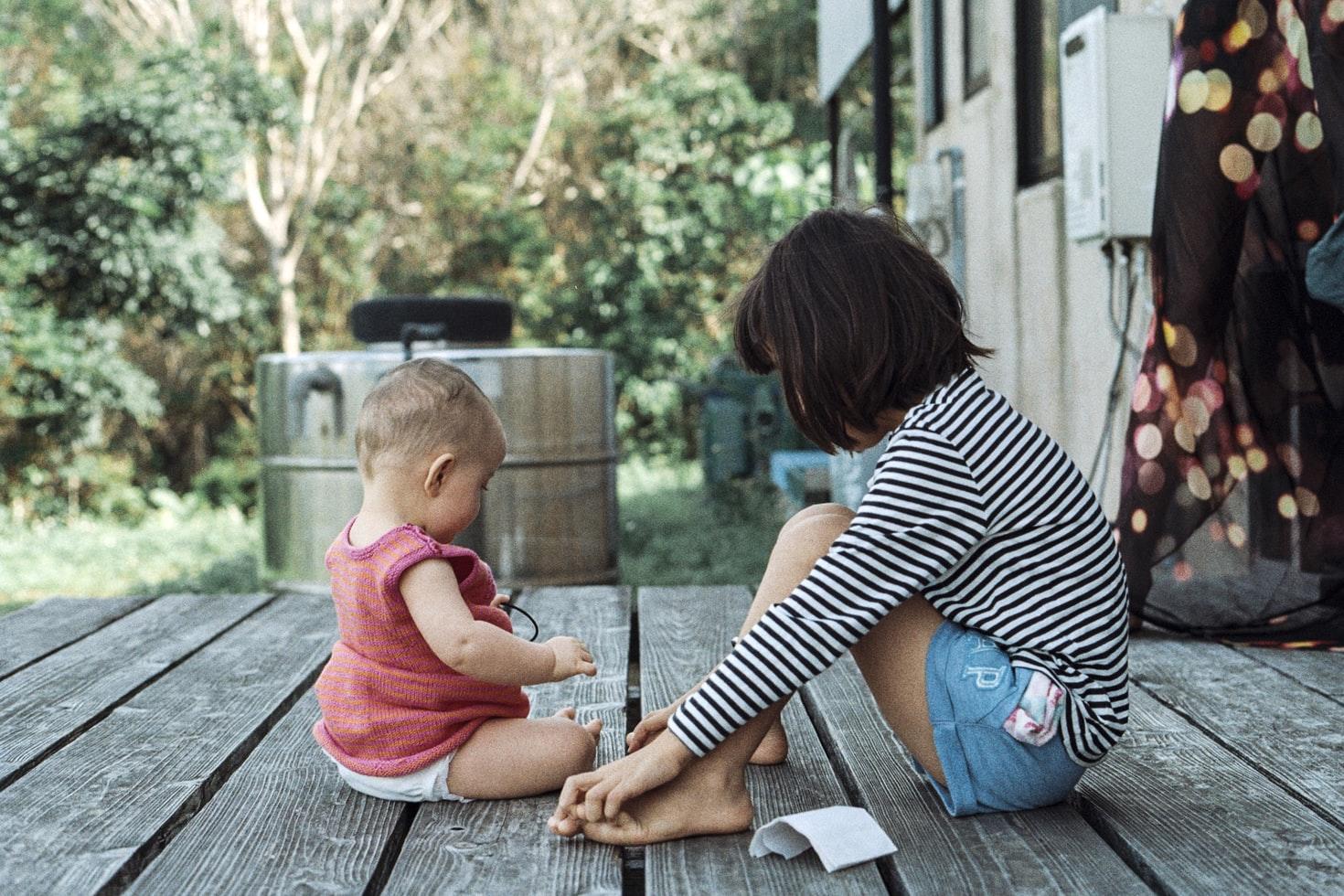 Niña al cuidado de una bebé
