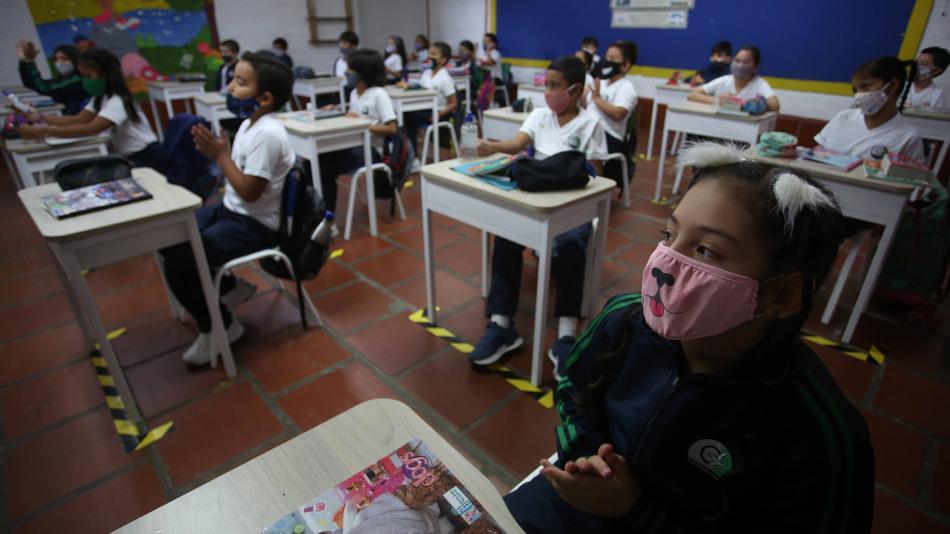 Chicos con mascarillas en salon de clases