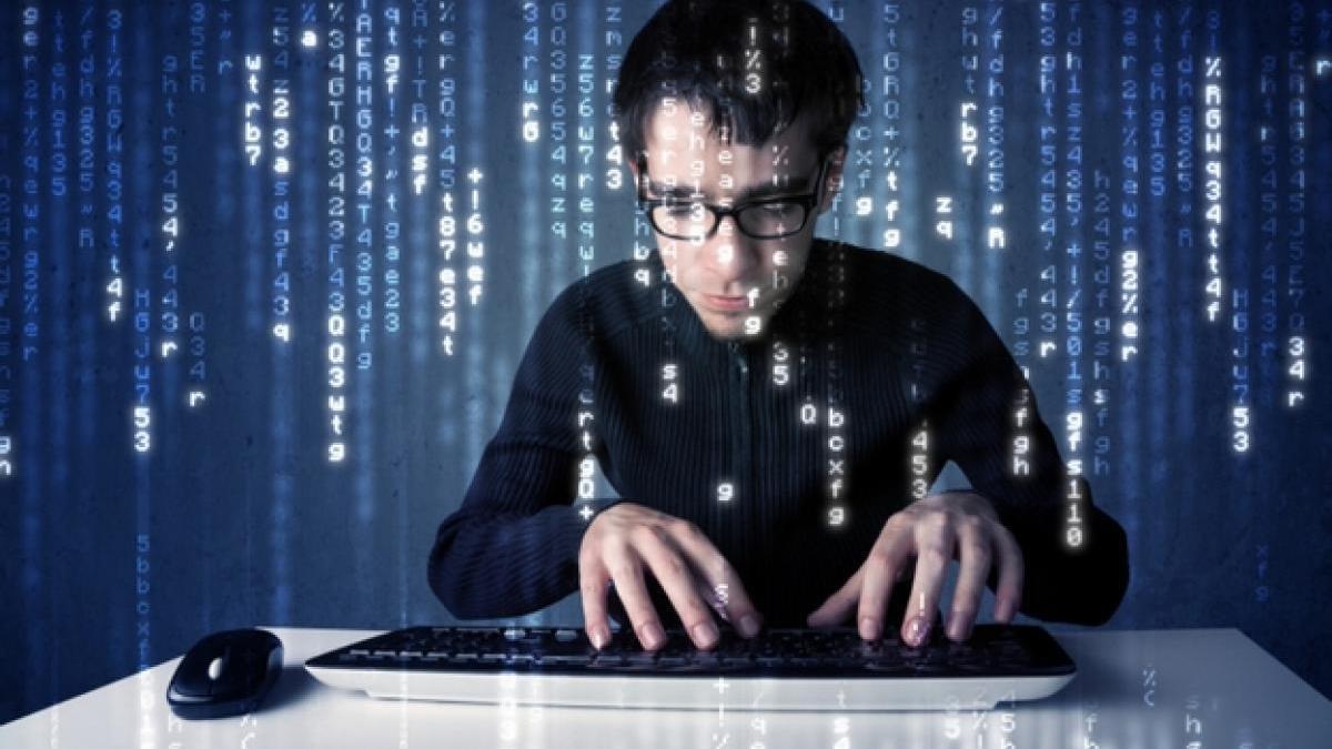 Hombre introduciendo un código binario en un tablero de cristal con ayuda de un teclado.