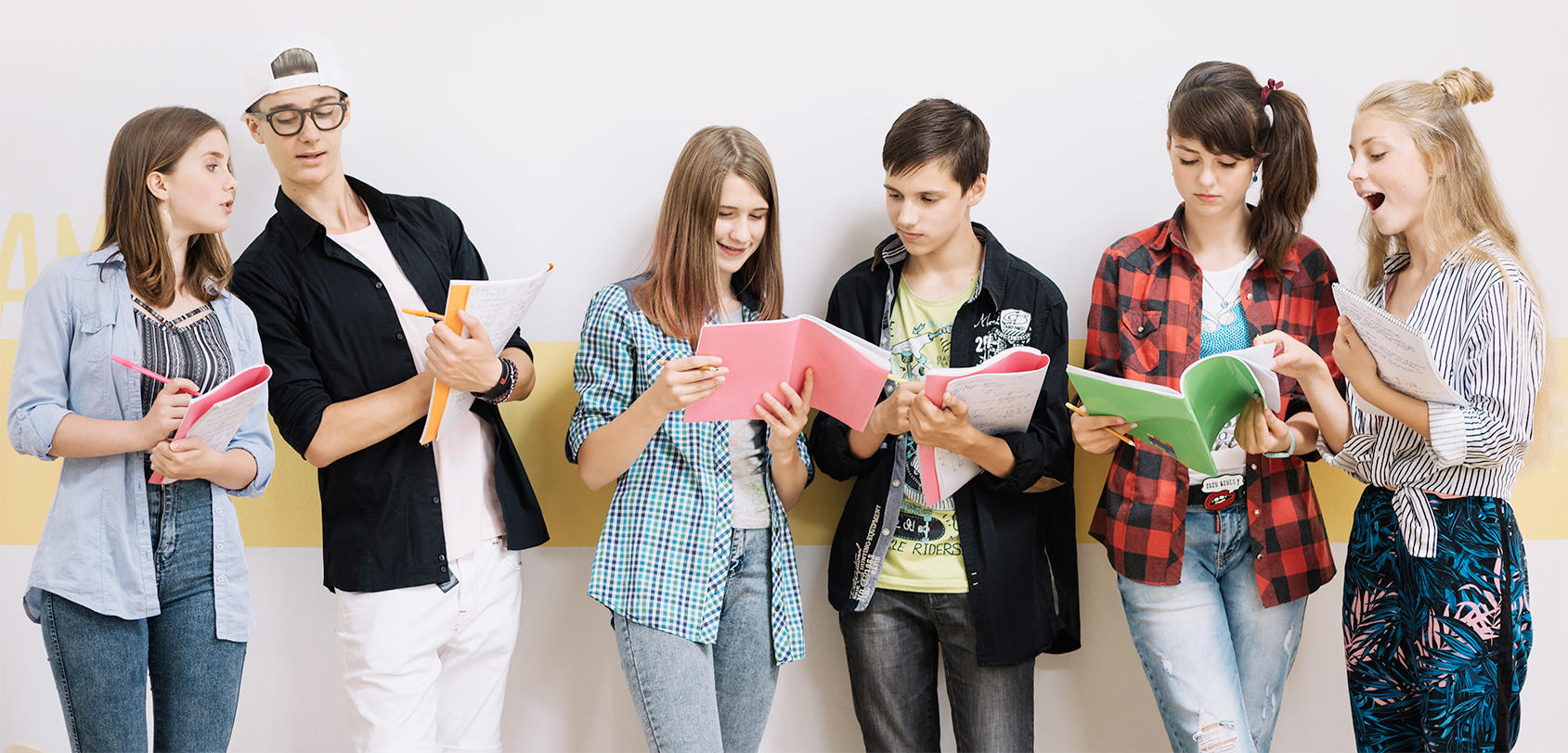 Cuatro chicas y dos chicos analizando libros y departiendo