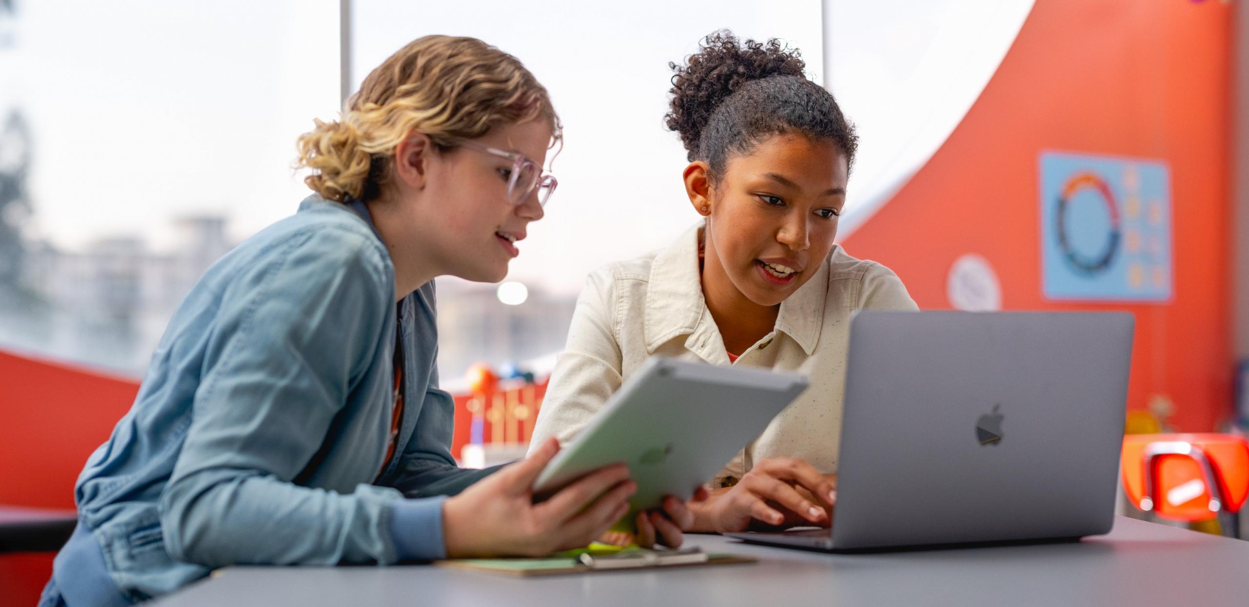 Profesora y estudiante de programación viendo un portátil.
