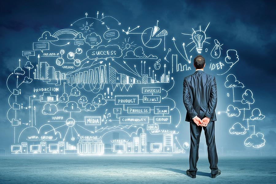 Hombre de espaldas, contemplando unos gráficos en la pizarra 