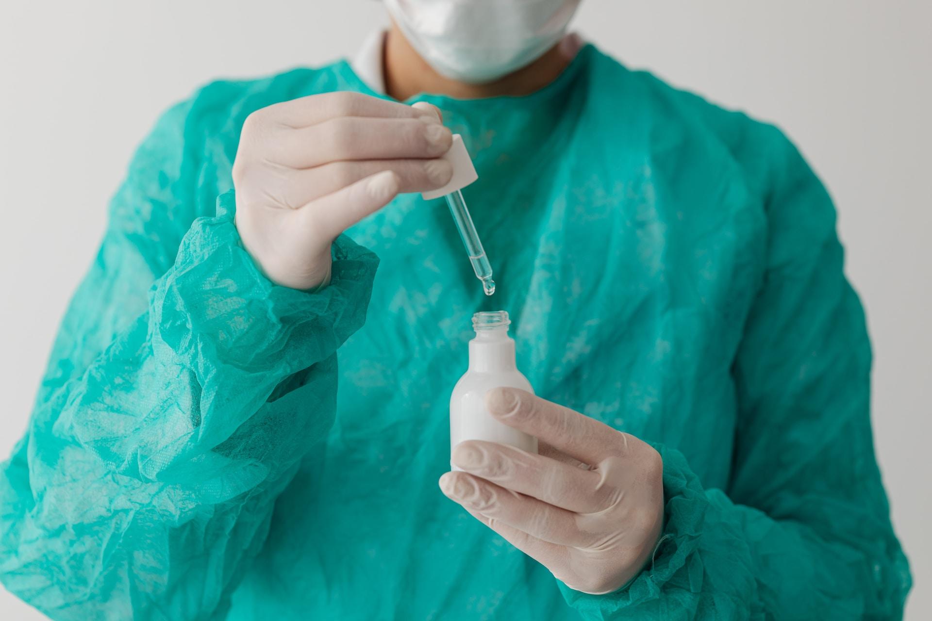 Profesora de química con un traje antifluido realizando un experimento en un laboratorio.