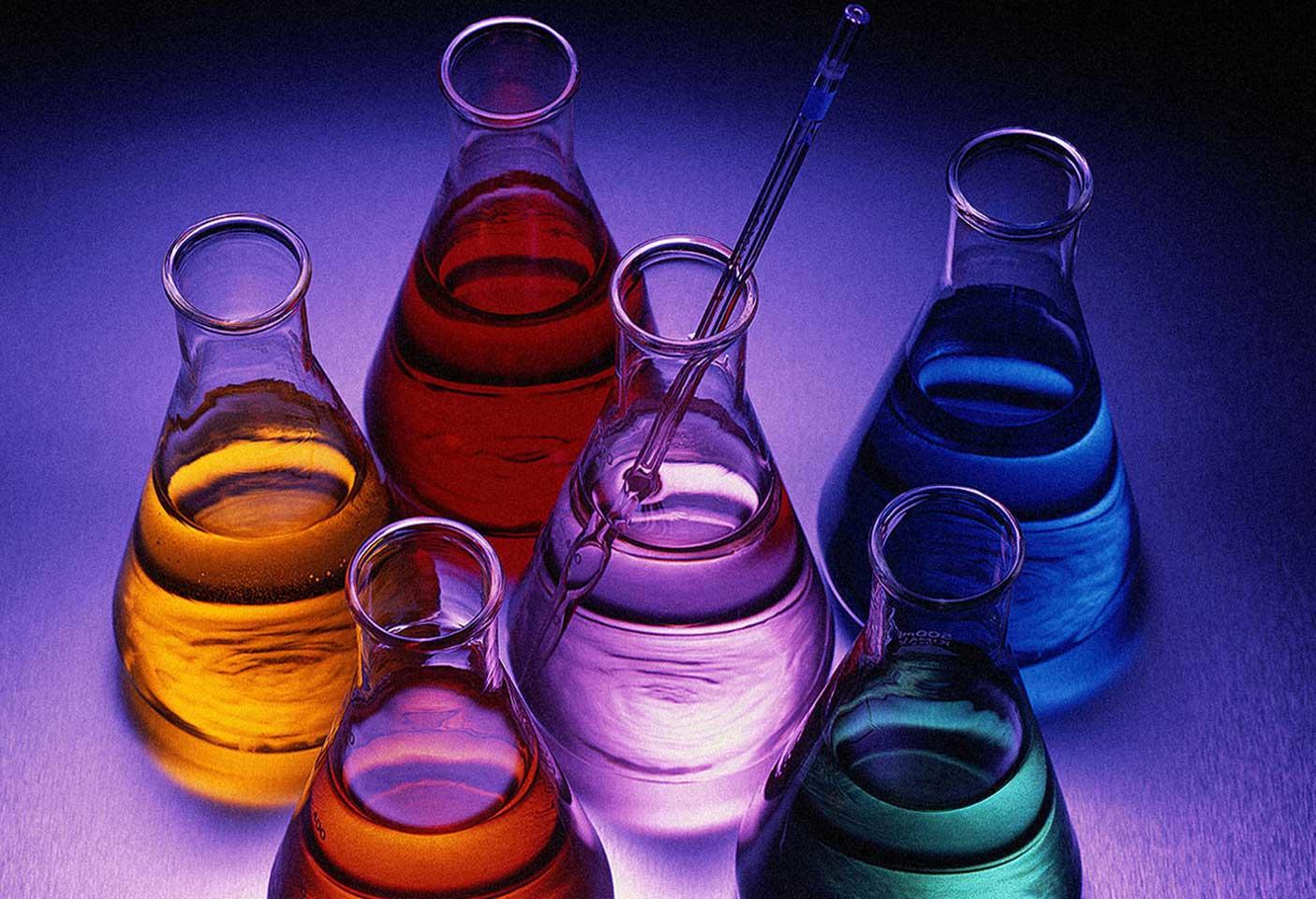 Cristaleria de un laboratorio químico, con líquidos de colores.