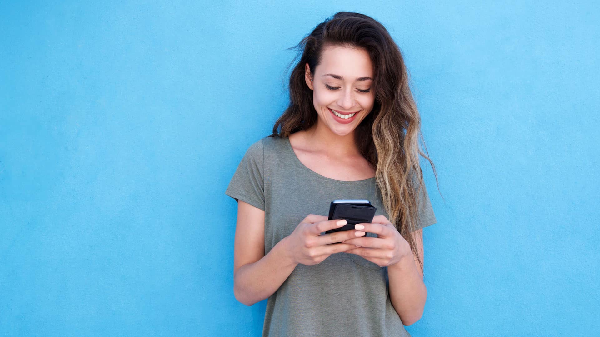 Chica sonriendo en su celular.