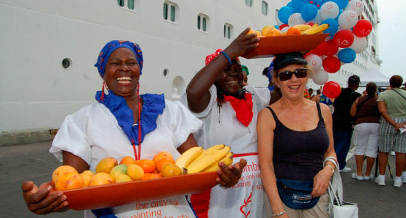 Ciudadana extranjera con dos mujeres con traje tradicional y cesto con frutas