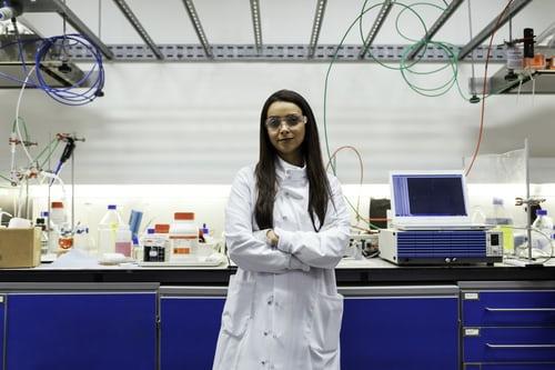 Ingeniera química, sonriendo dentro de un laboratorio.
