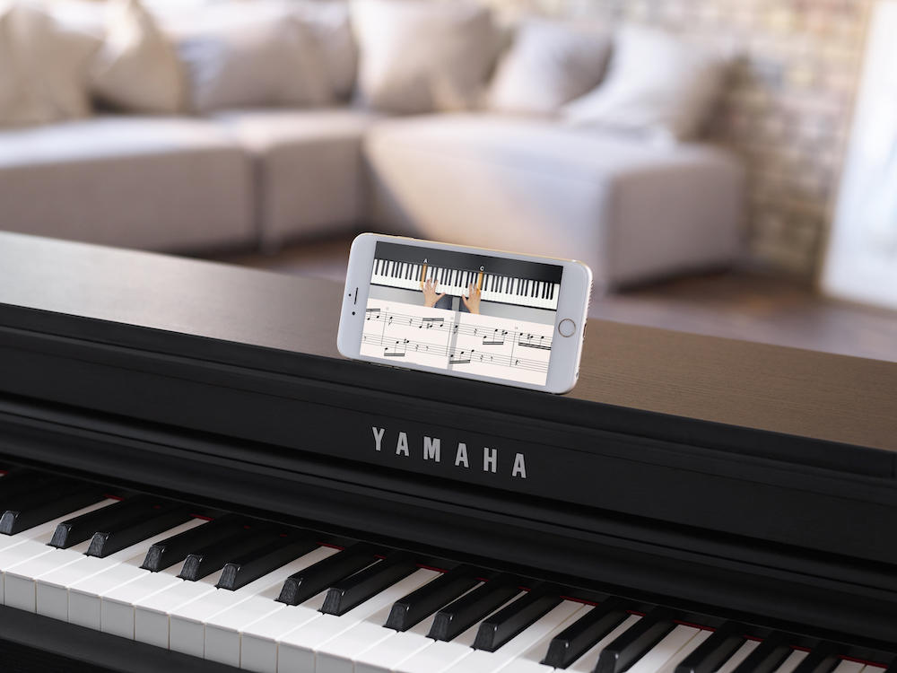 Iphone con Flowkey abierto sobre teclado yamaha