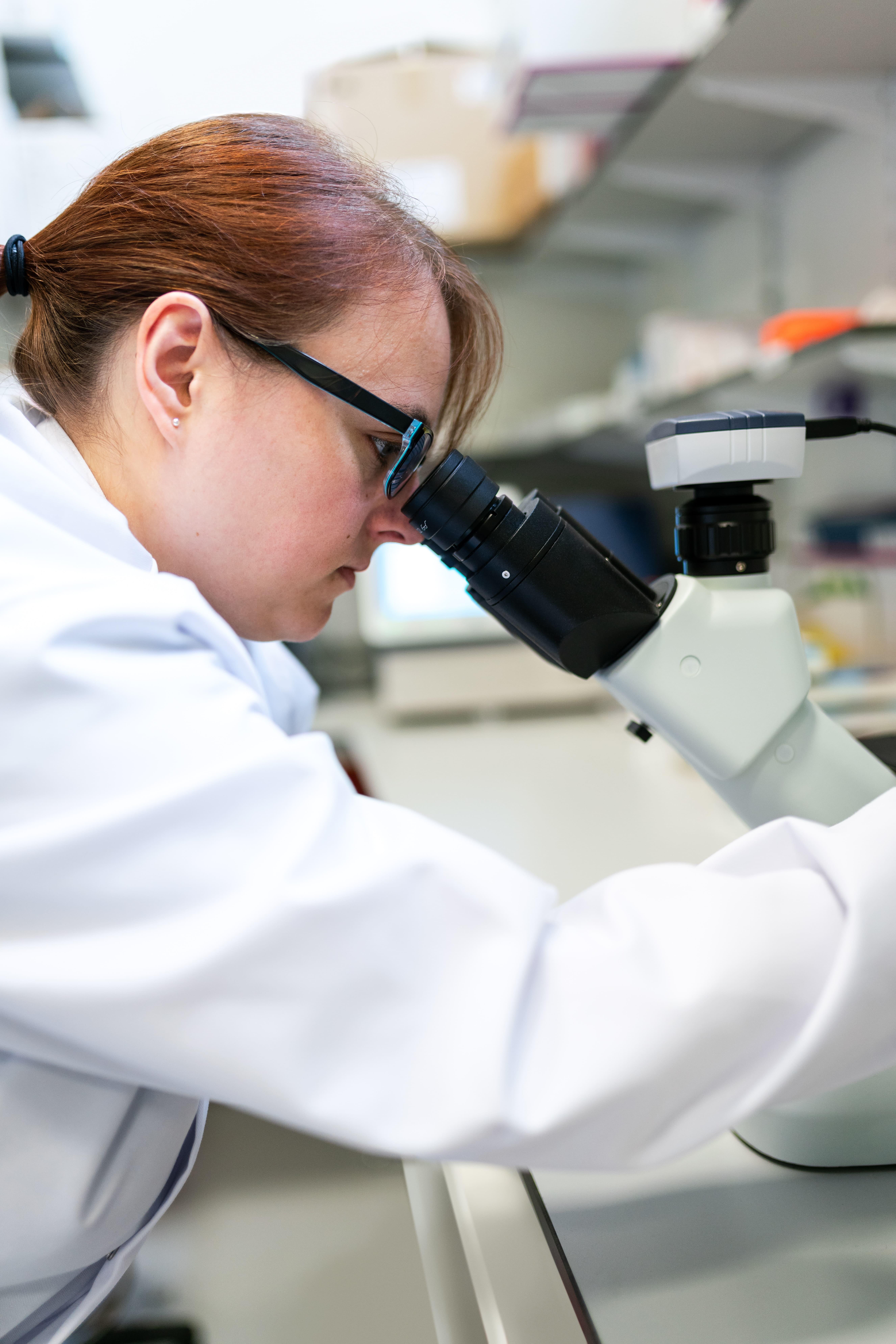 investigadora con un microscopio