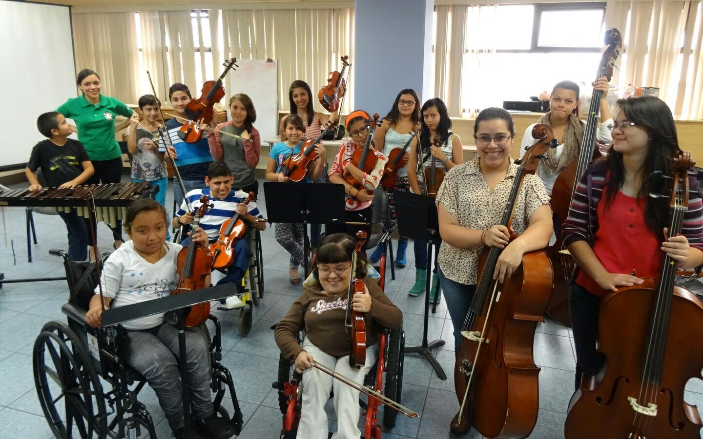 Varios niños discapacitados y en silla de ruedas posando con su grupo musical para una foto