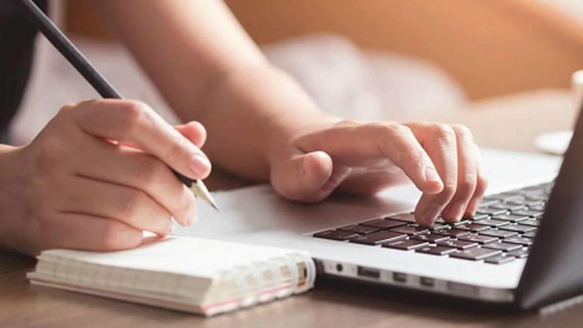 Manos sentado un esfero sobre el teclado de un pc.