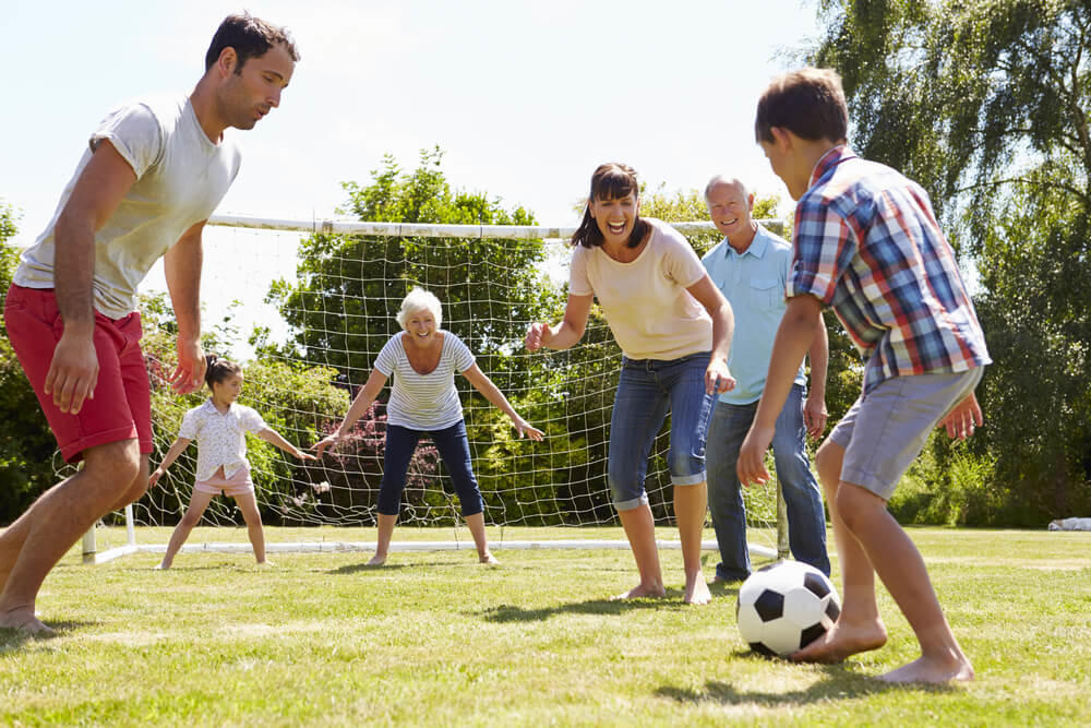 Padres hijos y la abuela jugando al futbol, actividad familiar
