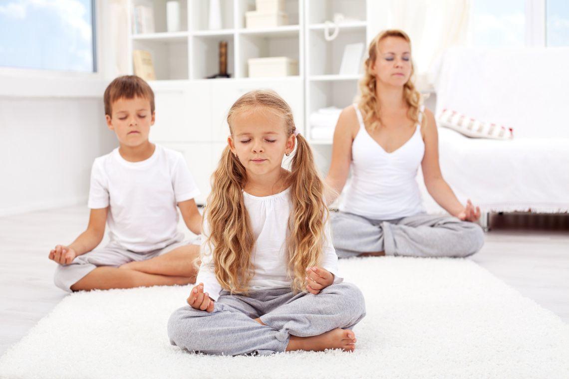 Madre haciendo yoga con su hijo e hija