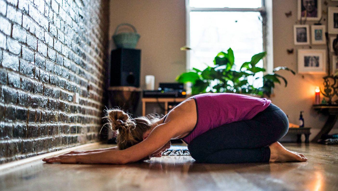Mujer haciendo estiramientos de yoga en casa