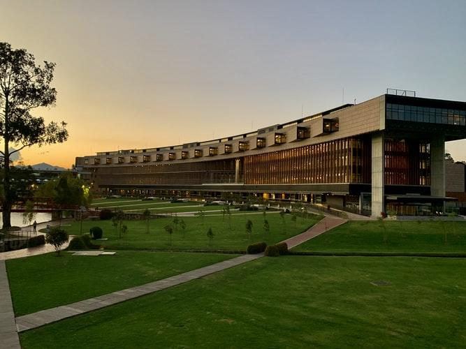 Edificio Marrón con un gran campo de hierba verde.