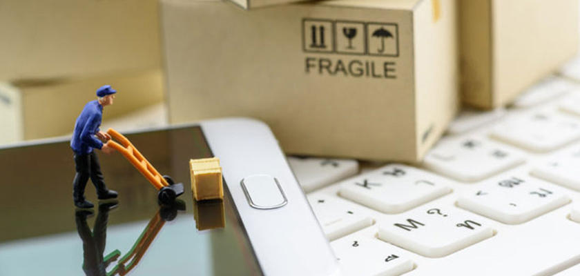 Muñeco de operario moviendo una caja sobre un Smartphone