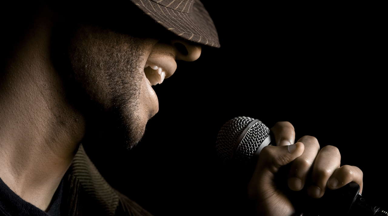 Cantante con sombrero alejándose del micrófono