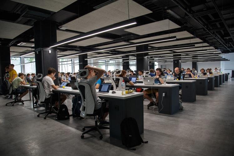 Grupo de programadores y desarrolladores, frente a sus computadora trabajando en un código abierto.