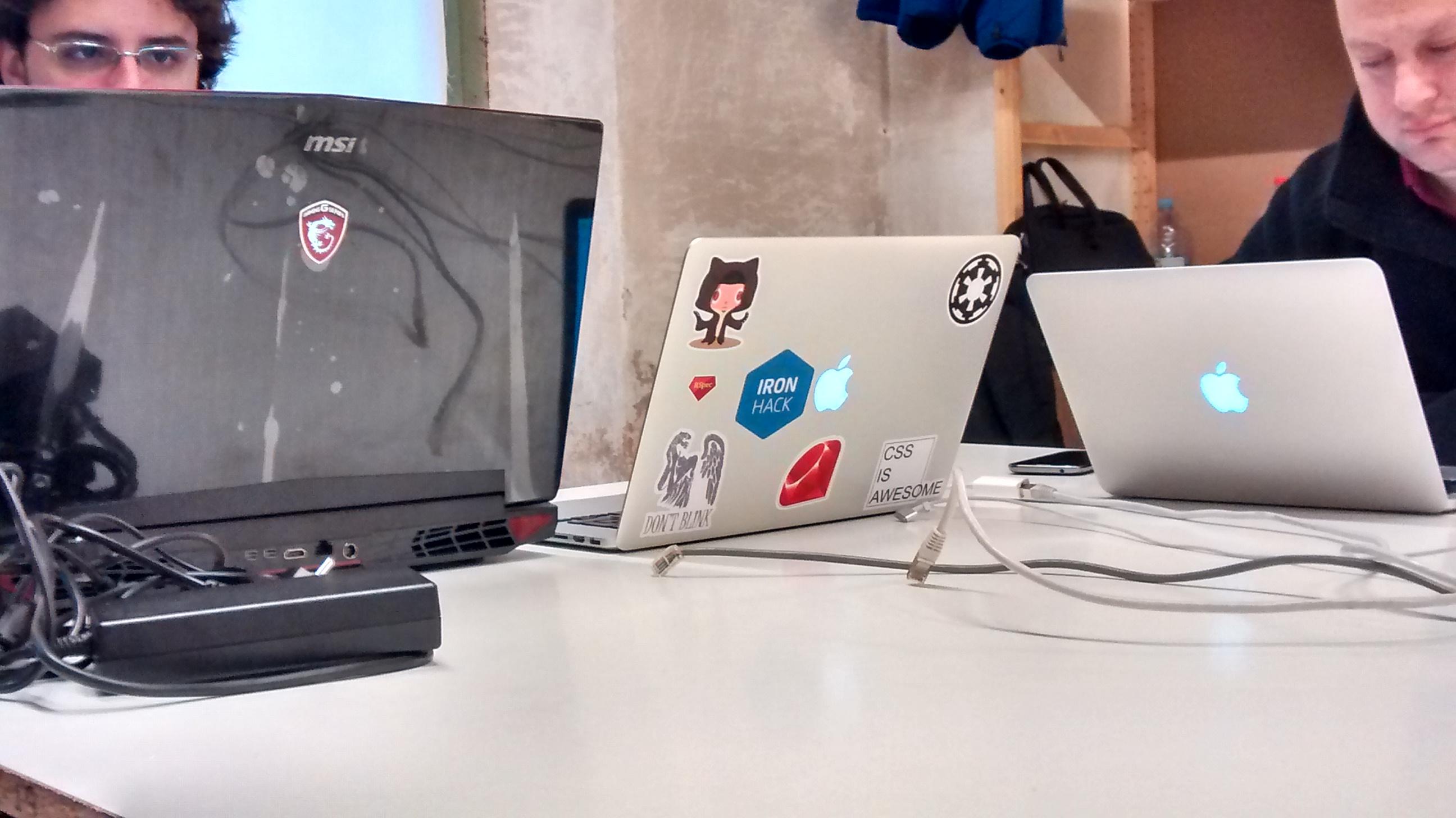 Programadores frente a un escritorio haciendo uso de sus computadoras.