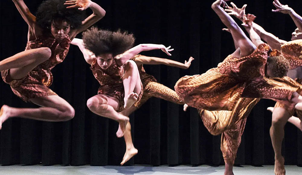 4 personas afro bailando y saltando al ritmo de la danza