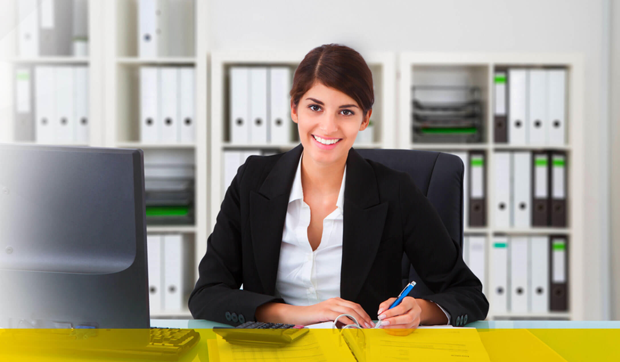 Contadora púbica sentada detrás de un escritorio, con una expresión de felicidad y una gran sonrisa.