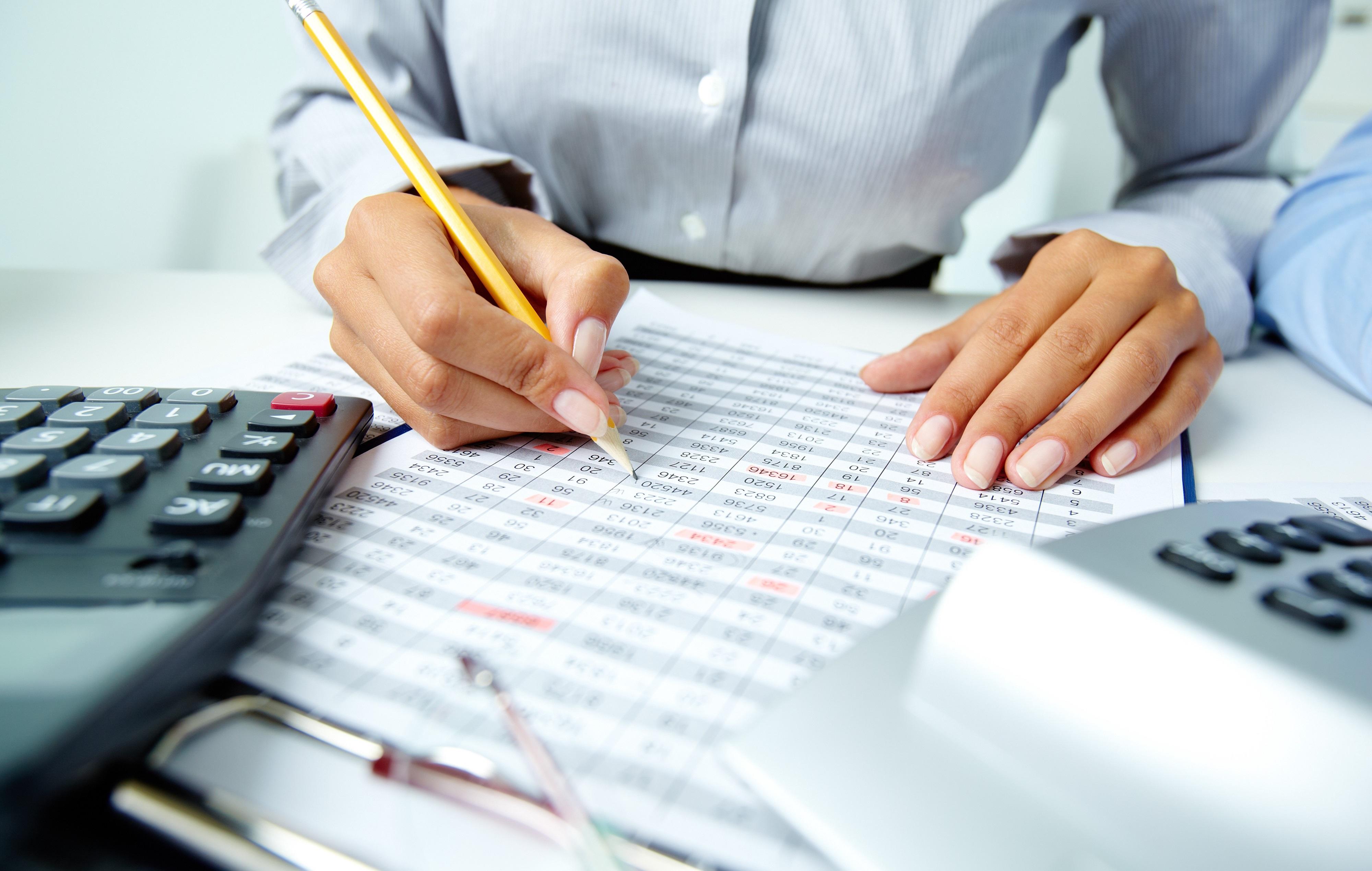 Contador sentado frente a un escritorio tomando notas con un lápiz