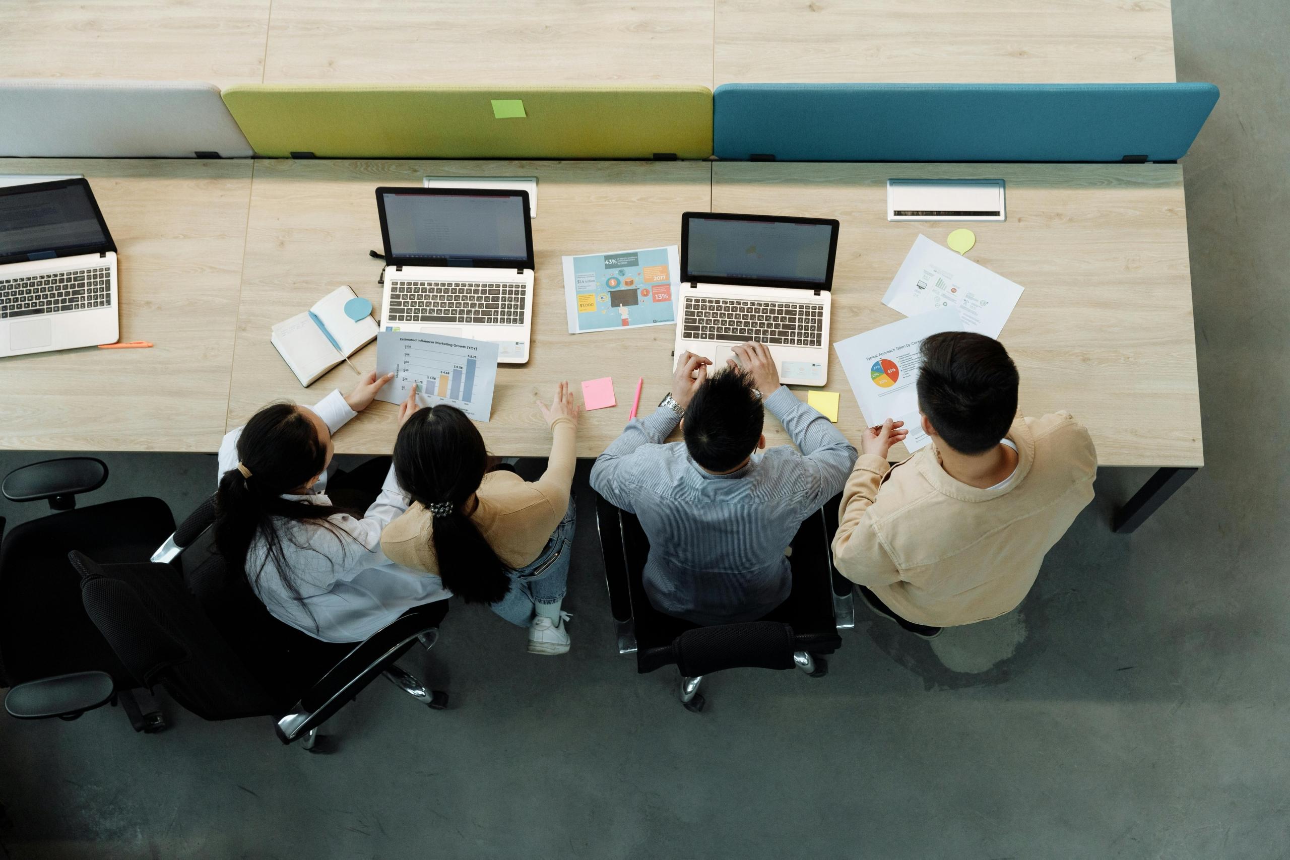 cuatro personas trabajando y analizando estádisticas y patrones de datos