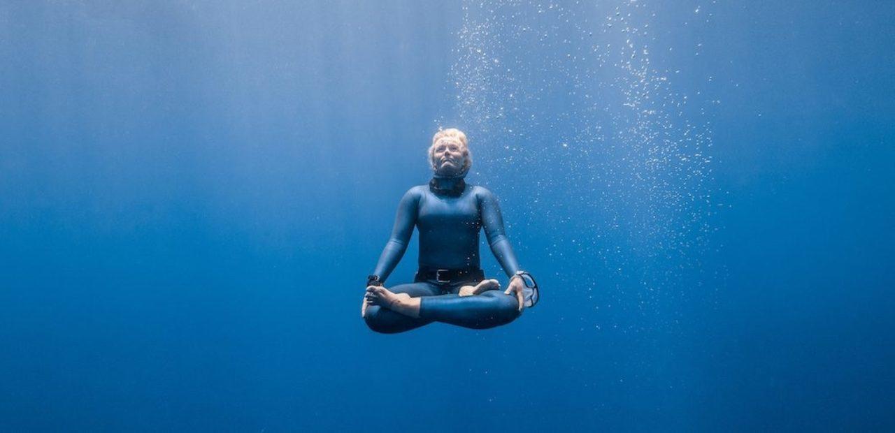 Georgina Millet sentada en posición de meditación, resistiendo la respiración bajo el agua