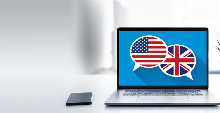 Portátil sobre una mesa, mostrando las banderas de EE.UU e Inglaterra.