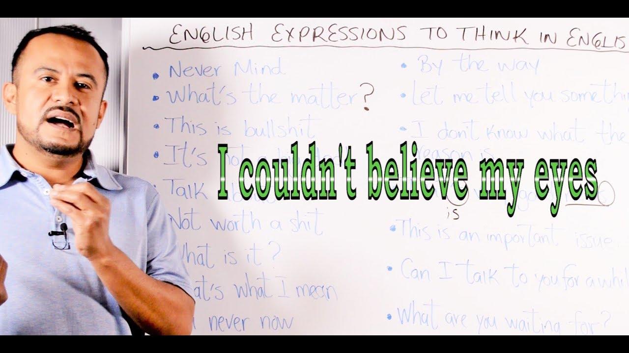 Hombre delante de un pizarrón que ésta lleno de expresiones en inglés.