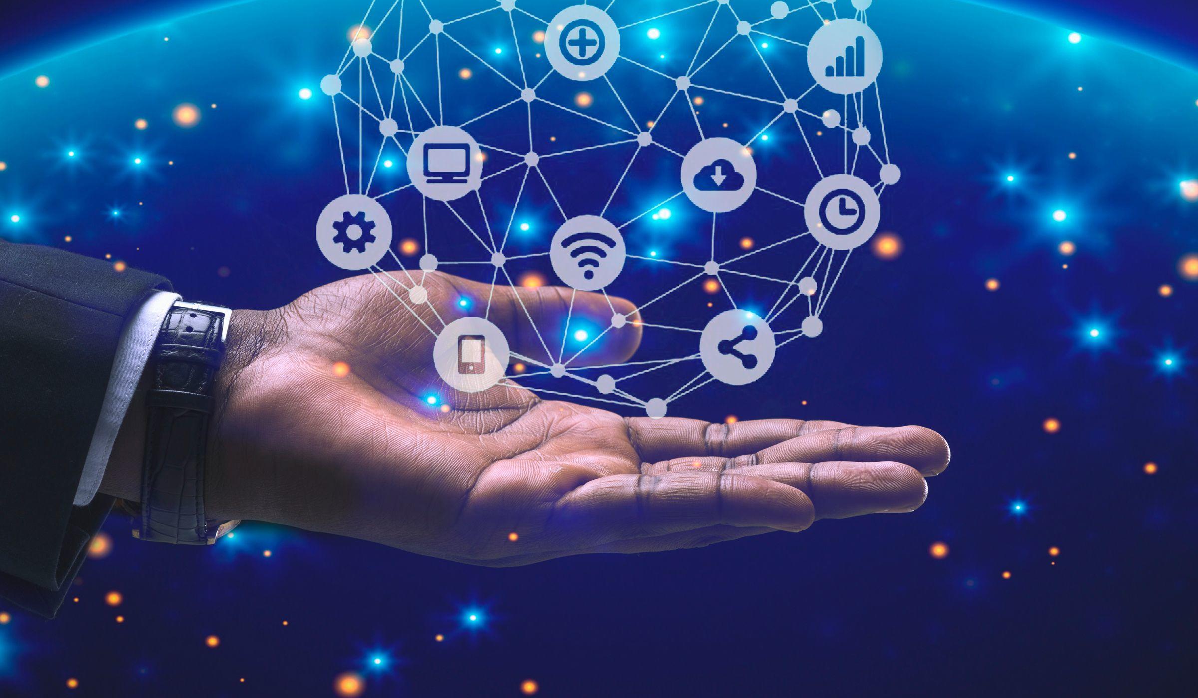 Mano extendida, sobre la cual se proyectan logos relacionados con la informática.