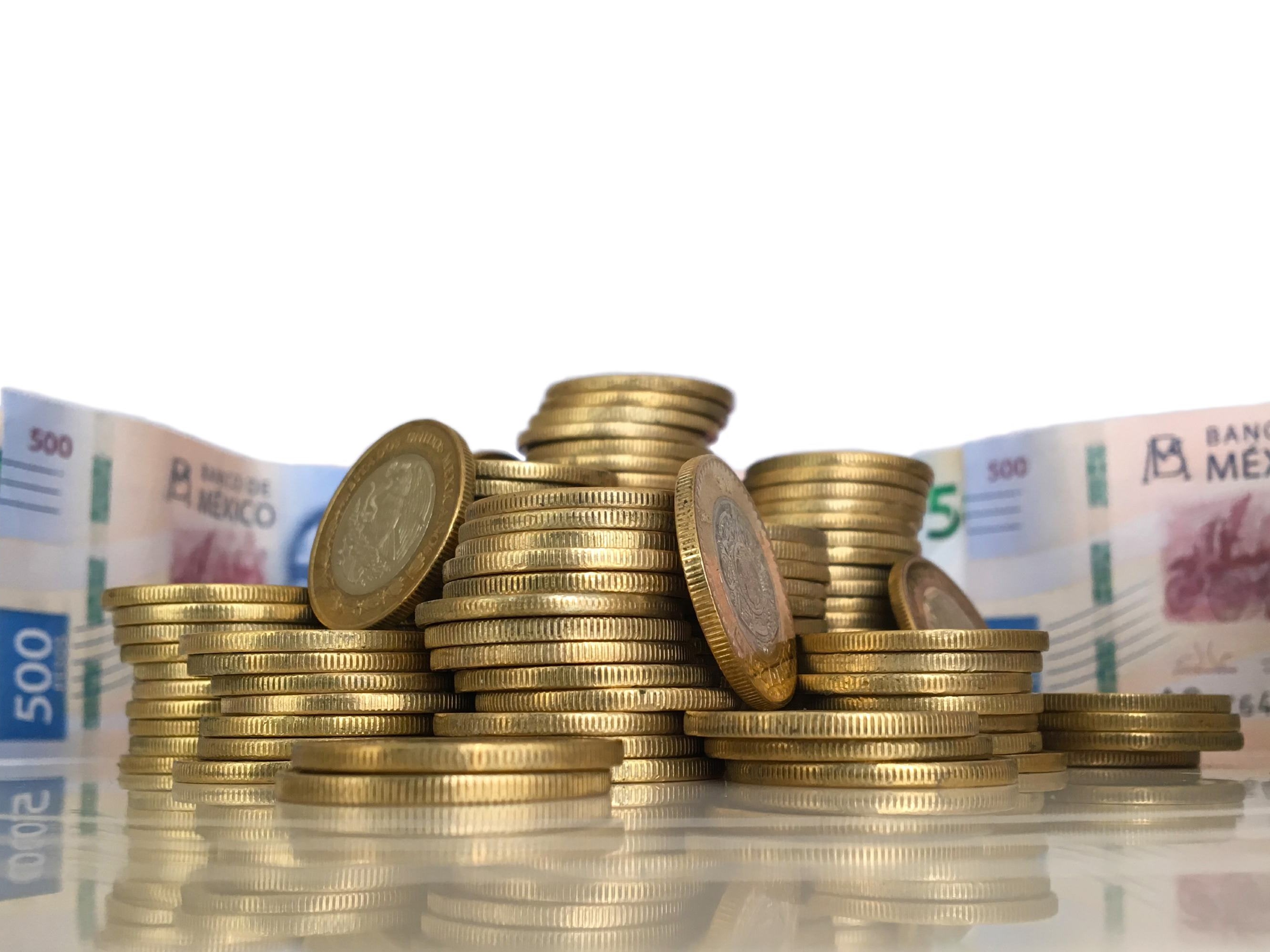 Montones de monedas junto a billetes